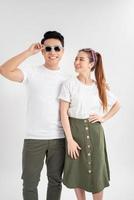 Surprised young couple looking at camera. Front view of excited young man and woman standing together and looking at camera on white background. Emotion concept photo