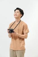 Confident photographer. Handsome young man holding digital camera and smiling while standing against white background photo