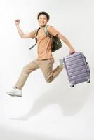 Young creative man is posing with suitcase on white background. photo