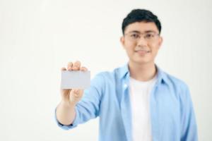 apuesto hombre de negocios sosteniendo una tarjeta de presentación en blanco aislado sobre fondo blanco, asiático foto
