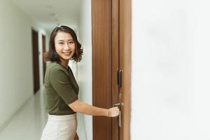 Woman hand holding modern door handles electronic lock open the door of apartment photo