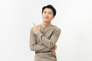 Smiling young handnsome Asian man pointing hand to empty space aside photo