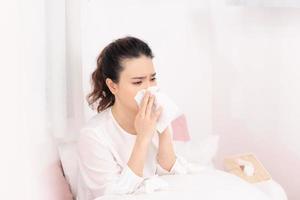 Sick woman covered with a blanket lying in bed with high fever and a flu, resting. photo