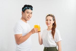A young couple drink OJ on white background photo