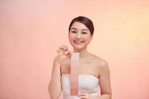 Portrait of beautiful young woman holding different human skin tone plate set photo