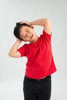 Frustrated Little Asian boy screaming with both hands holding his head isolated on white background. photo