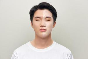 Front portrait of a white male wearing a mud mask beauty treatment. photo