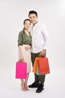 pareja feliz con bolsas de compras, de pie cerca uno del otro con una sonrisa. foto