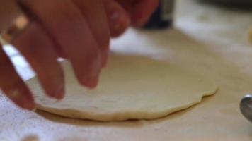 A woman cooks pies at home. Cooking and baking at home. Preparing dough for baking. Test batch. A woman prepares fried yeast dough pies in a home kitchen. Handmade food preparation concept.