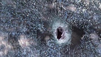 Bullet hole in glass with cracks, real bullet hole close-up. Authentic shot. The bullet made a cracked hole in the windshield of a car or a window glass shattered as a result of an accident. video