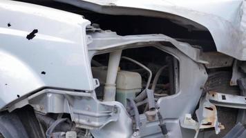 faros rotos como resultado de una colisión. coche gris roto después de un accidente. concepto de accidente automovilístico. faro de emergencia, capó y parachoques dañados. daños a la carrocería del automóvil después del accidente. video