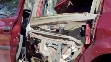 kaputtes auto nach einem unfall. Die Karosserie eines Autos wird bei einem schweren Autounfall nach einer Kollision am Unfallort auf einer Stadtstraße beschädigt. das konzept der verkehrssicherheit und versicherung. video