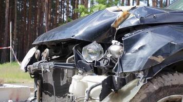 voiture noire après un terrible accident sur le bord de la route. choc frontal et latéral. assurance-vie. un accident sans possibilité de guérison. vue de côté. dommages après un accident. video