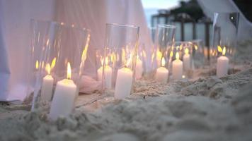 Décoration lumineuse aux chandelles sur la table de dîner de plage de sable mariage