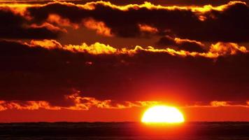 vista escénica de cerca de la puesta de sol más allá del horizonte sobre el mar, lapso de tiempo. video
