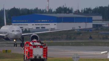 MOSCOW, RUSSIAN FEDERATION JULY 29, 2021 - Boeing 777 of Aeroflot taxis on the airfield at Sheremetyevo International Airport SVO. Fire rescue vehicle at the airport video