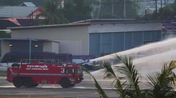 phuket, tailândia, 26 de novembro de 2016 - caminhão de bombeiros do aeroporto pulverizando água na pista. caminhão de bombeiros em um teste simulado