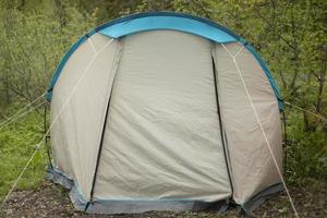 Tourist tent in forest. Tent for sleeping in nature. Equipment for going to park. photo