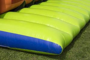 Green trampoline. Inflatable design. Details of amusement park. photo