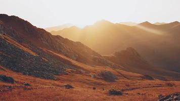 uomo e donna Due escursionisti nel distanza escursione su pista all'aperto su bellissimo tramonto nel autunno insieme. lento movimento contro sole attivo persone su trekking nel Caucaso montagne