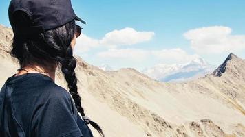 porträtt av caucasian kvinna stå på synpunkt. sorglös turist kvinna ser på Sol njuter landskap. flicka resande på topp av topp deda ena njut av panorama av kaukasus video