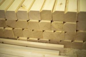Bars of wood in row. Blanks in carpentry workshop. Wooden material for cutting. photo