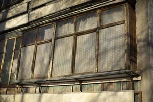 Old balcony in house. Wooden window frames. Building is in detail. photo