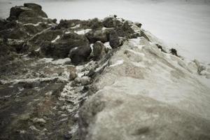 Dirty snow by road. Side of road in winter. Blocks of ice are black. photo