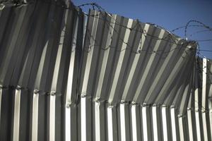 Broken fence. Fence from profile sheet bent. Rumpled iron. photo