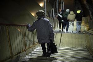 Pensioner goes down stairs in evening. Old woman walks down steps. photo