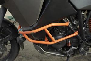 Motorcycle protection. Bike is in details. Orange steel shock blocker. photo