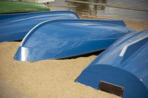 Blue boats lie on sand. Boat station on beach. photo