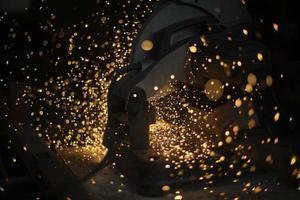 Sparks in dark. Cutting steel. Industrial equipment. photo