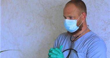 um homem com barba em um terno de médico verifica as luvas video