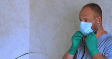 A man with a beard in a doctor's suit puts on a mask video