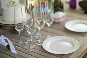 Plates and glasses on table. Table on veranda. Details of holiday. Preparing for dinner. photo