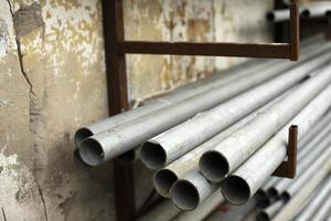Steel pipes are in stock. Lots of cut metal pipes. Warehouse details. photo