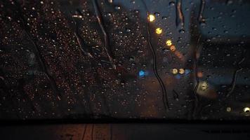 Rain moving on the windshield While parked on a city street in a heavy rain storm at night. video