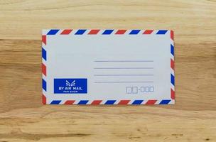 Envelope by air mail isolated on wood photo