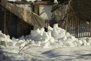 I'm on old barn. Snow fell from cabin. Snowy winter in Russia. photo