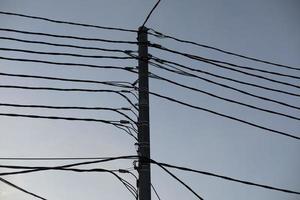 cables eléctricos en poste. muchos cables contra el cielo. foto