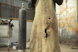 Old apron. Work clothes. Torn piece of cloth. Apron in holes. photo