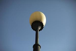 Pole with lamp in city. Ancient pillar. Urban light in 18th century. photo