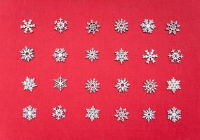 Decorative white Christmas snowflakes non-repeat ornament in geometrical order on the red textured background, simple abstract texture photo