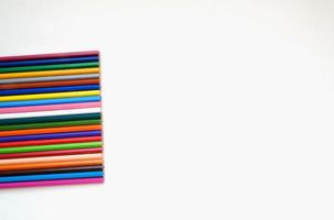 Colored pencils conceptual composition on the white background, top view creative flatlay with copyspace for your artwork display or any design photo