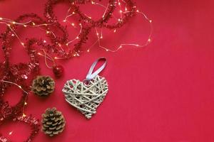 Bright red Christmas flat lay with decorations, garland and wooden decorative heart, family celebrations concept with copy space for your design photo