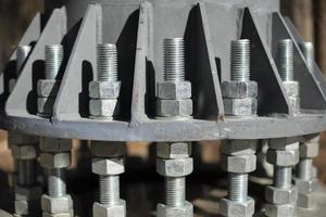 Nuts on bolts. Base of communication pole. Steel structural elements. photo