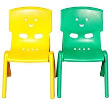 Two colored children's plastic chairs with funny faces on the back. photo