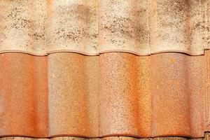 Texture of a wavy brown tile roof with splashes. photo