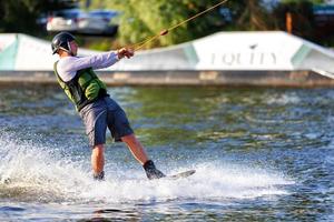 Athlete man dynamically rides on a water board on a summer day. 06.19.1922. Kyiv. Ukraine. photo